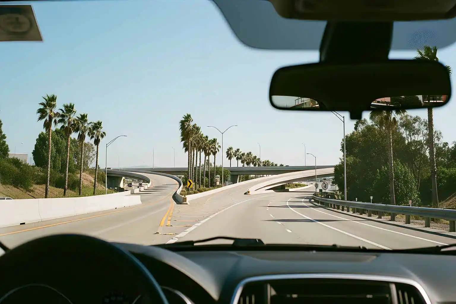 Straße mit Abzweigung aus der Fahrerperspektive als Metapher für Entscheidungen und Erfahrungen im Fotografieprozess